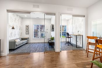 A living room with a grey couch and a wooden chair.